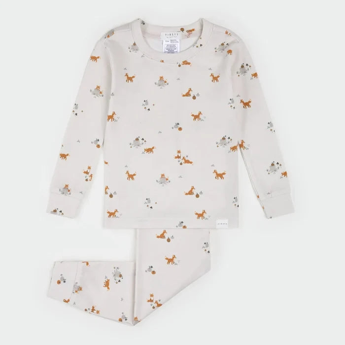 A two-piece children's pajama set by Fabris, featuring a long-sleeve top and matching pants in a warm cream color with an all-over print of orange foxes, brown rabbits, and gray squirrels. The brand label 'FABRIS' is visible on the inner neck tag.