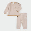A two-piece baby clothing set featuring a long-sleeve top and matching pants in a beige and white stripe pattern, laid flat on a light gray background.
