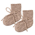 Pair of beige knitted baby booties on a white background
