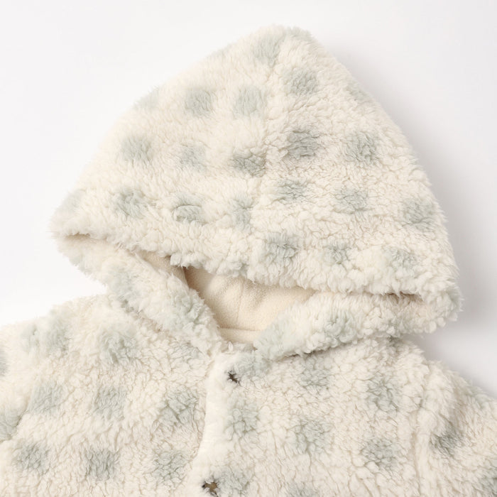 Close-up of a plush sherpa hooded jacket in cream with pale sage green polka dots, featuring a soft lining and snap-button closure.