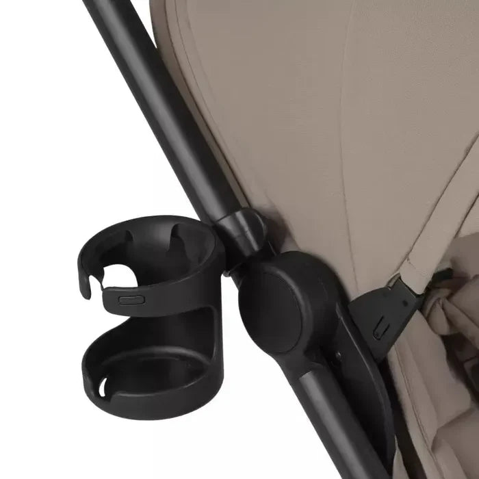 Black cup holder attached to a beige stroller on a white background