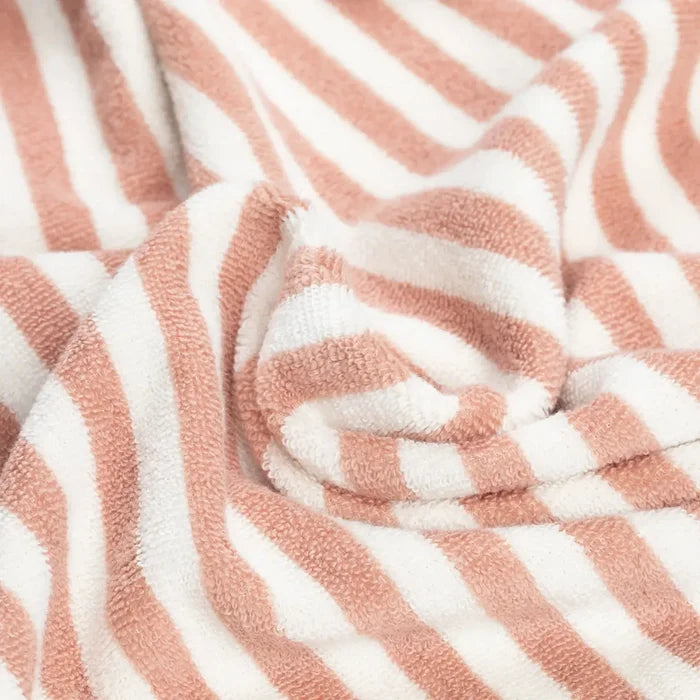 A close-up of a soft, textured fabric with alternating dusty pink and off-white stripes, gathered in the center to show its plush terry texture.