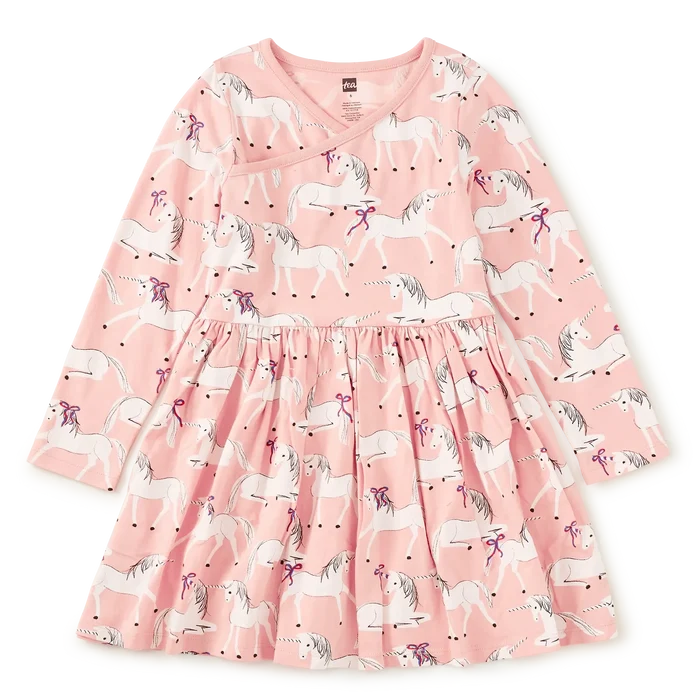 A pink long-sleeve dress with an all-over unicorn print, featuring a gathered waist and a V-neckline, shown flat against a white background.