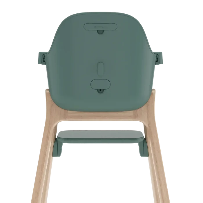 Rear view of a high chair with a muted sage green plastic seat and a light natural wood frame, shown on a solid white background.