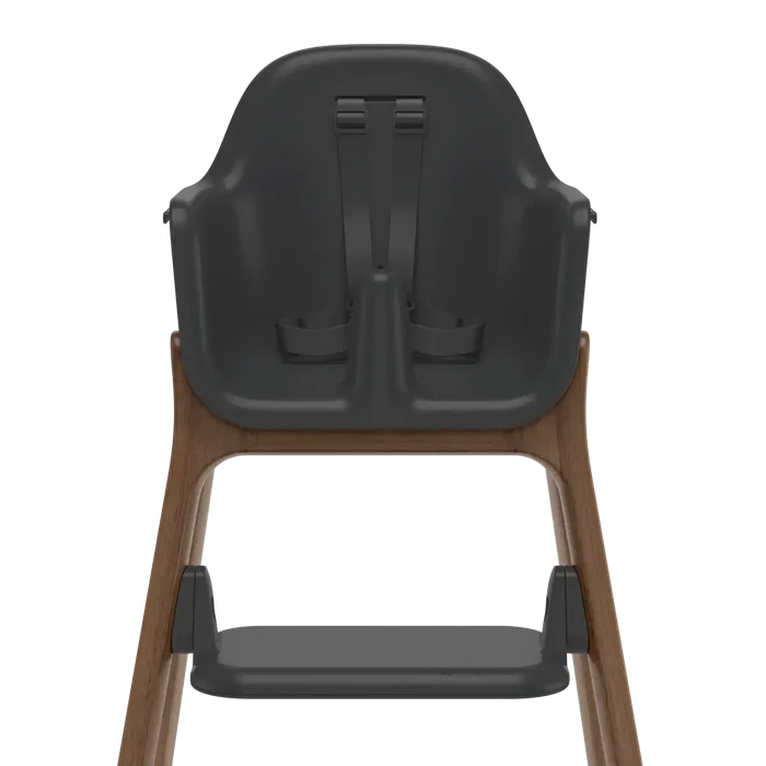 Rear view of a high chair with a dark gray molded plastic seat and harness, supported by a medium brown wooden frame, on a solid white background.