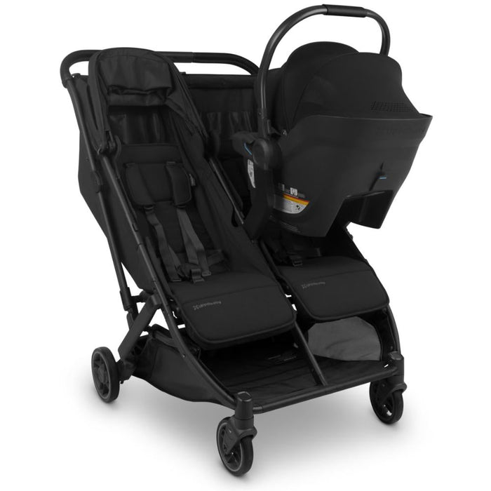 Black double stroller with one car seat attached on a white background