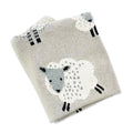 Knitted blanket with sheep design on a white background