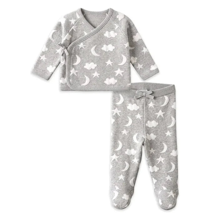 A baby two-piece footed sleeper set in heather gray, featuring a long-sleeve wrap top and matching pants, both decorated with a white celestial pattern of stars, moons, and clouds.