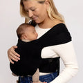 Woman carrying baby in a black wrap on a white background